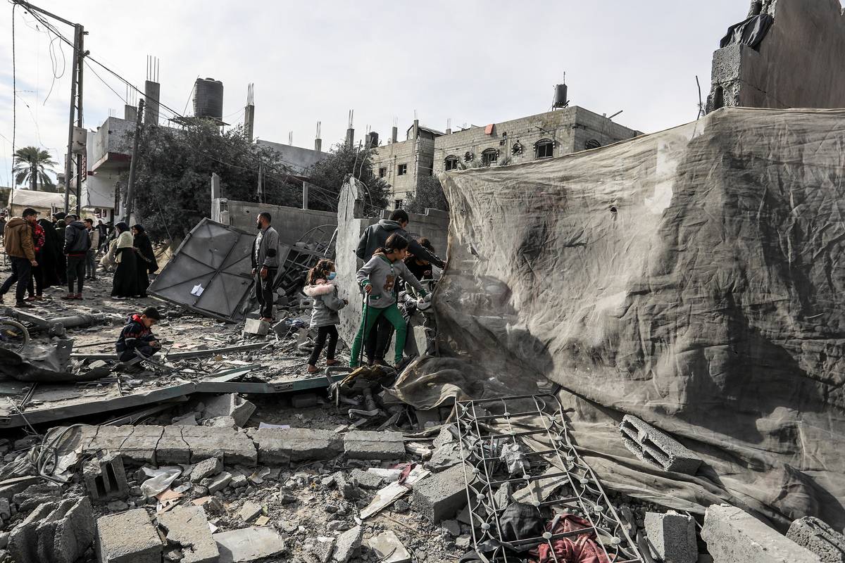 Palestinians, including children, collect usable belongings in the heavily damaged buildings, part of which collapsed, after Israeli attacks in Rafah, Gaza on February 12, 2024. [Abed Rahim Khatib - Anadolu Agency]