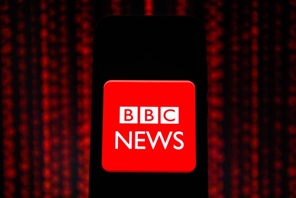 In this photo illustration a BBC news logo seen displayed on