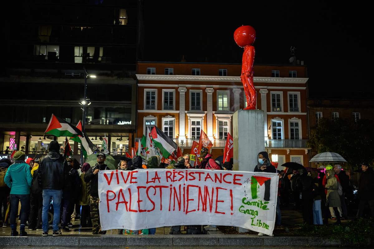 Protesters, waving Palestinian and union flags and holding a banner reading "long live Palestinian resistance", attend a rally organised by French unions CGT, Solidaires and FSU in support to the Palestinian people, next to a statue named "L'Homme a la tete de pomme" made by French artist James Colomina in Toulouse, southwestern France, on November 2, 2023. [LIONEL BONAVENTURE/AFP via Getty Images]