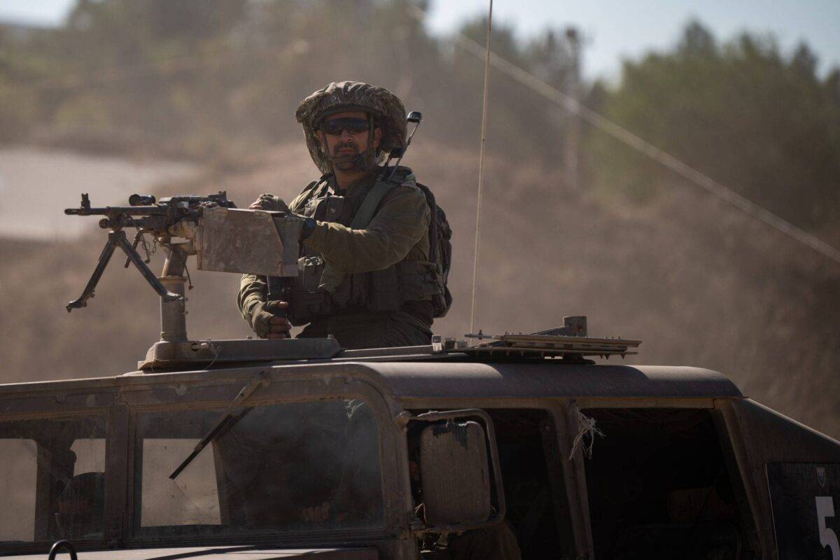 An IDF soldier positioned on machine gun looks out while on a hummer near the Gaza border in Southern, Israel on 17 November, 2023 [Alexi J. Rosenfeld/Getty Images]