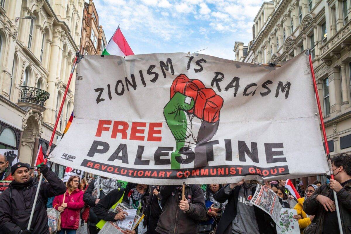Pro-Palestinian protesters in London, UK hold a banner and chant at a demonstration calling for an end to Israeli attacks on Gaza on 9 December 2023 [Andy Soloman/UCG/Universal Images Group via Getty Images]