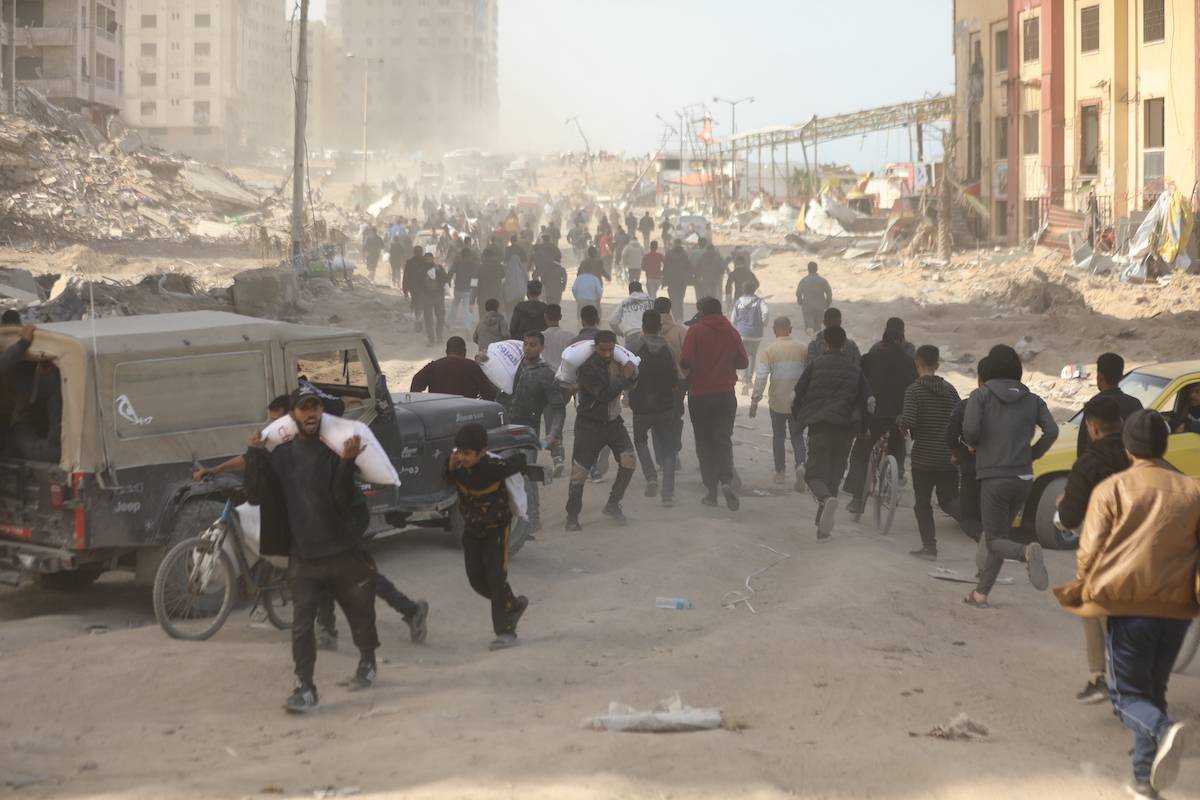 Palestinians, who are unable to meet their basic needs due to the Israeli army's obstruction of humanitarian aid, receive a bag of flour from an aid truck that arrived at al-Rashid Street in the west of Gaza City, Gaza on March 06, 2024. [Dawoud Abo Alkas - Anadolu Agency]