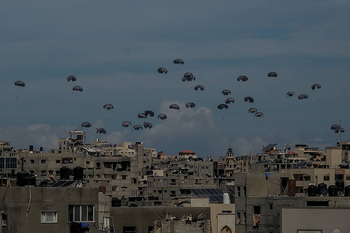Parachutes filled with aid boxes float down as planes drop humanitarian aid around various regions in the northern Gaza, Gaza on March 09, 2024. [Omar Qattaa - Anadolu Agency]
