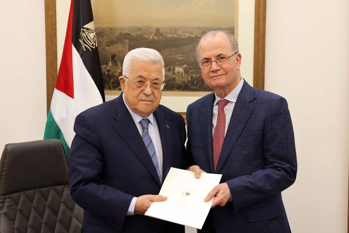 Palestinian President Mahmoud Abbas (L) poses for a photo with former Deputy Prime Minister and Chairman of the Palestinian Investment Fund Mohammed Mustafa (R) after appointed him as the new Prime Minister in Ramallah, West Bank on March 14, 2024. [Palestinian Presidency - Anadolu Agency]