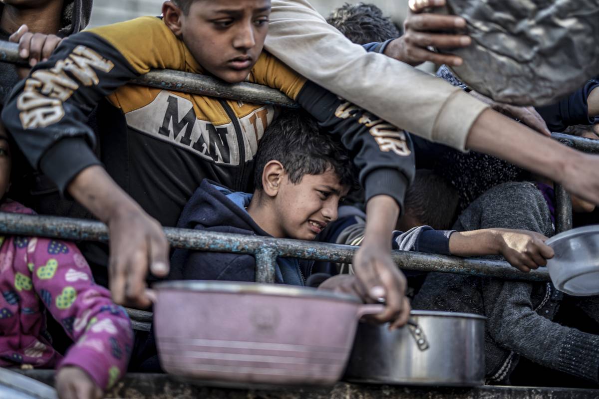 Palestinians in Rafah, Gaza, queue to receive food distributed by aid organizations on March 15, 2024. [Jehad Alshrafi - Anadolu Agency]