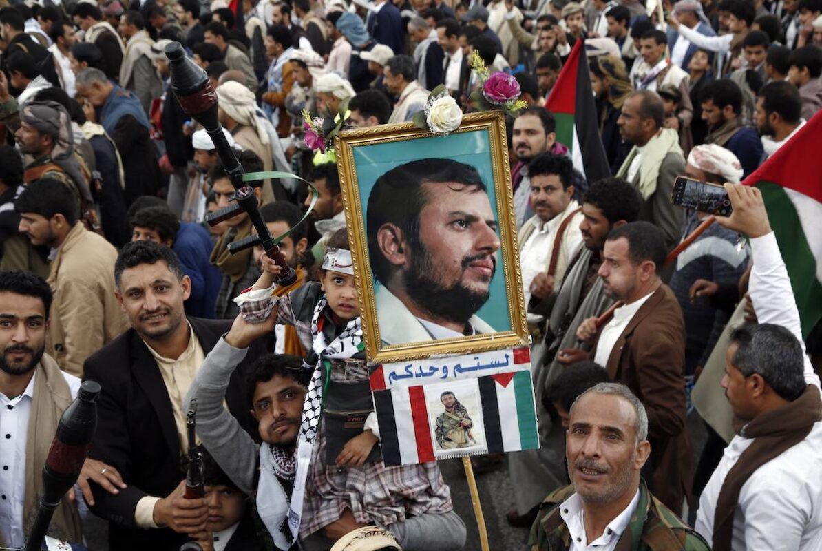 A Yemeni protestor lifts a poster featuring a portrait of the Houthi leader Abdul Malik Al-Houthi as he participates with others in a protest against Israel's continuing war in the Gaza Strip, on March 1, 2024, in Sana'a, Yemen. [Mohammed Hamoud/Getty Images]