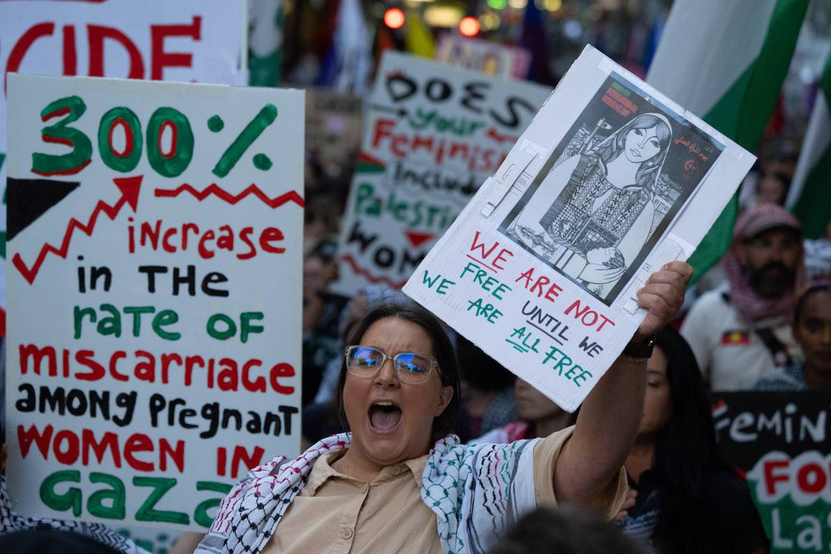 A protestor chants while holding a placard in reference to women's rights in Gaza marches during an International Women's day protest rally on March 07, 2024 in Melbourne, Australia. [Asanka Ratnayake/Getty Images]