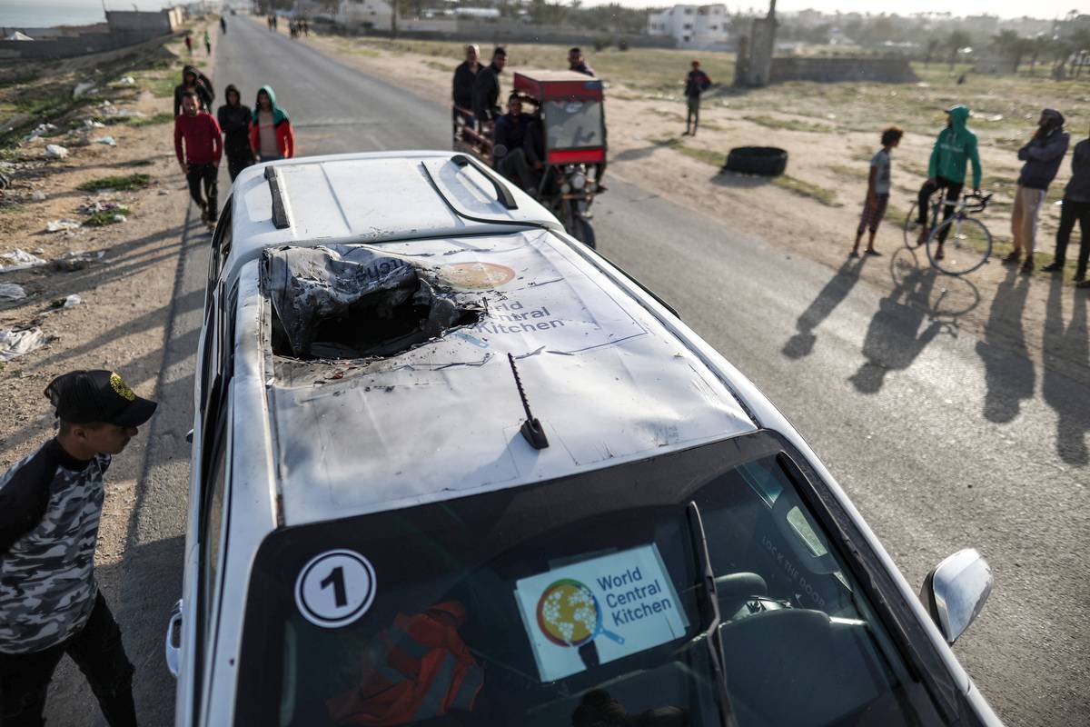 Residents inspect the damaged vehicle damaged vehicle carrying Western employees after Israeli attack in Deir al-Balah, Gaza on April 02, 2024. [Ali Jadallah - Anadolu Agency]