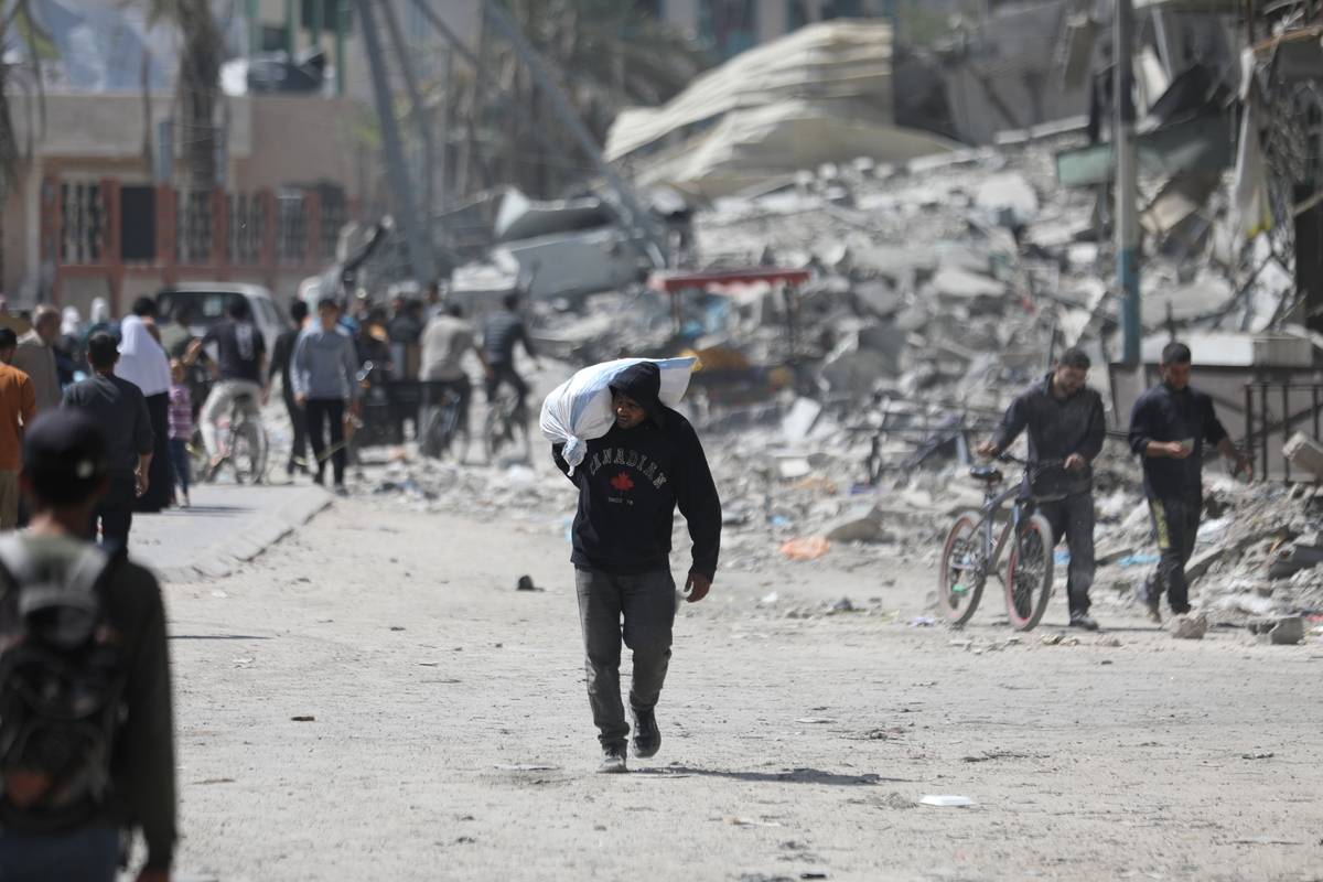 Palestinians, who are unable to meet their basic needs due to the Israeli army's obstruction of humanitarian aid, receive a bag of flour from an aid truck in the north of Gaza City, Gaza on April 03, 2024 [Dawoud Abo Alkas - Anadolu Agency]