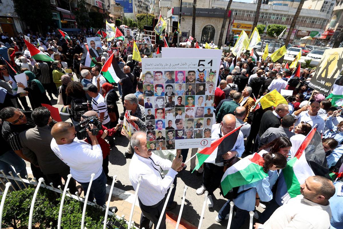 People attend a protest holding the photographs of prisoners in Israeli prisons and Palestinian flags during "17 April Palestinian Prisoners' Day" in Ramallah, West Bank on April 17, 2024. [Issam Rimawi - Anadolu Agency]
