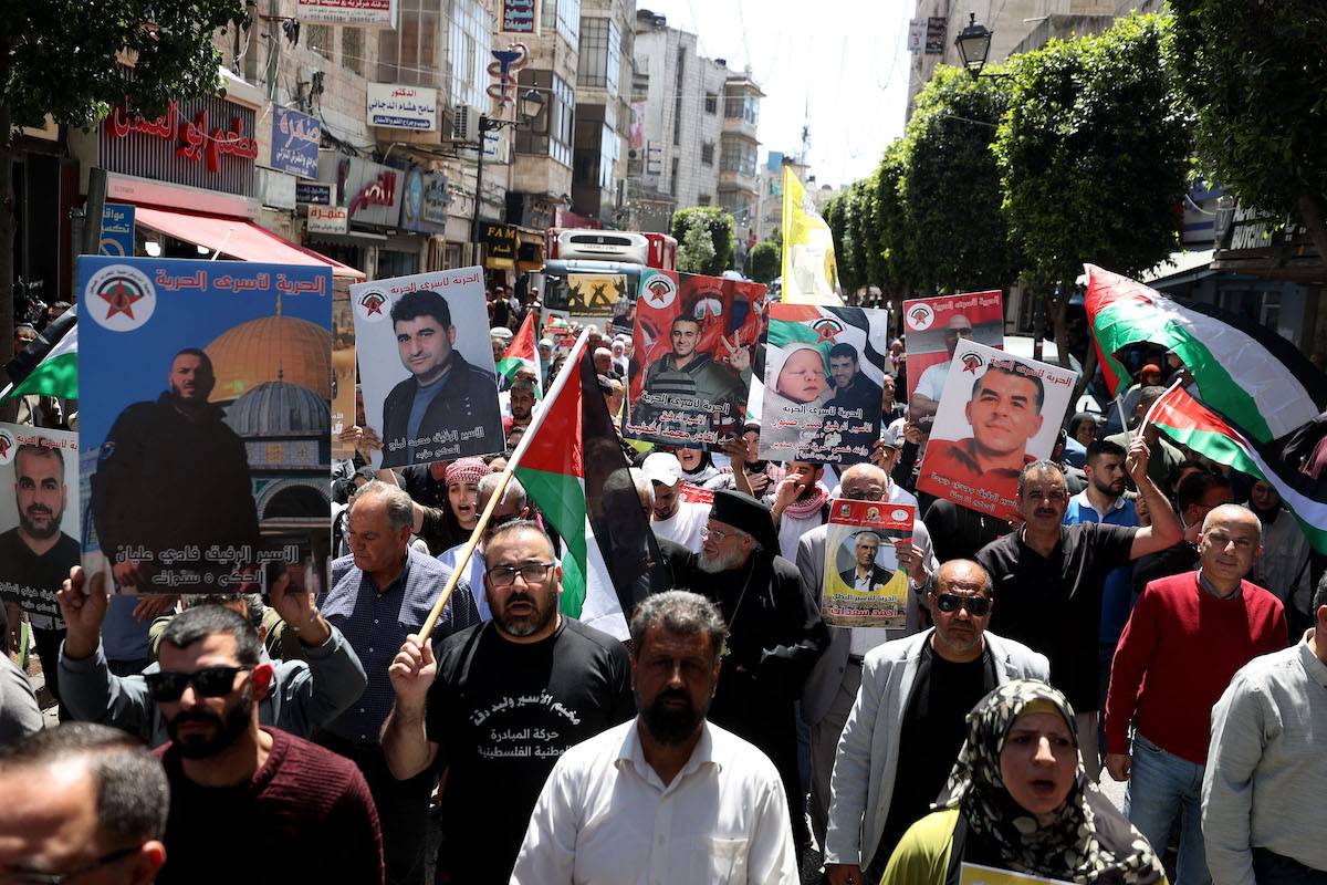 People attend a protest holding the photographs of prisoners in Israeli prisons and Palestinian flags during "17 April Palestinian Prisoners' Day" in Ramallah, West Bank on April 17, 2024. [Issam Rimawi - Anadolu Agency]