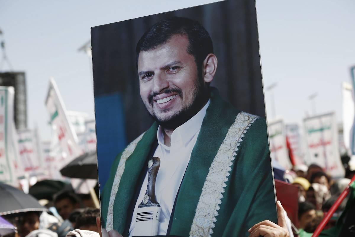A protestor lifts a placard depicting the Houthi leader Abdul Malik Al-Houthi while participating in a protest staged in solidarity with Palestinians and back Yemen's Houthis attacks against Israel, the US, and the UK, on March 22, 2024, in Sana'a, Yemen. [Mohammed Hamoud/Getty Images]