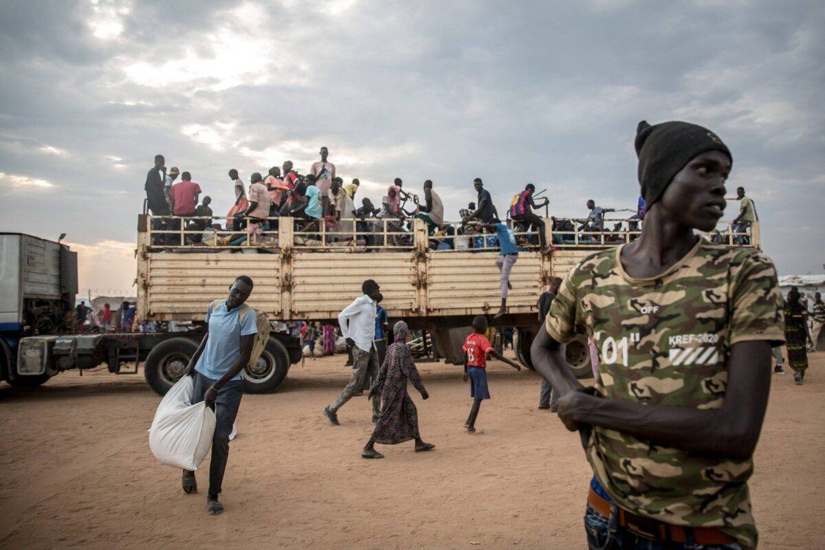 People fleeing the Sudanese war disembark a truck which has