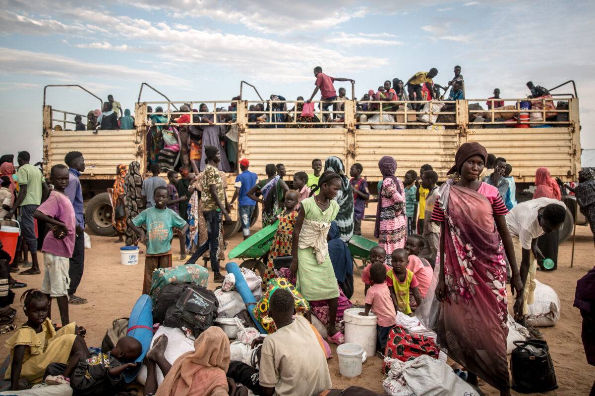 People fleeing the Sudanese war disembark a truck which has