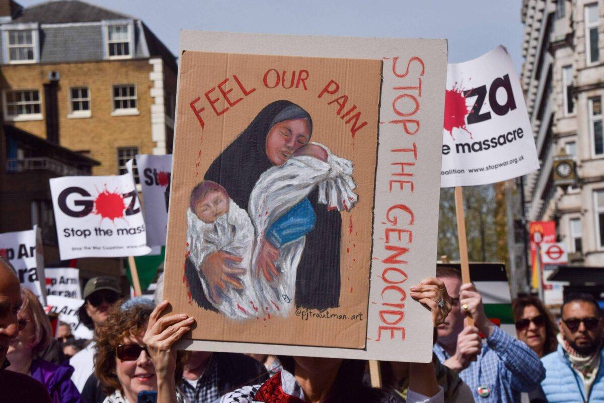 A protester holds a 'stop the genocide' placard during the