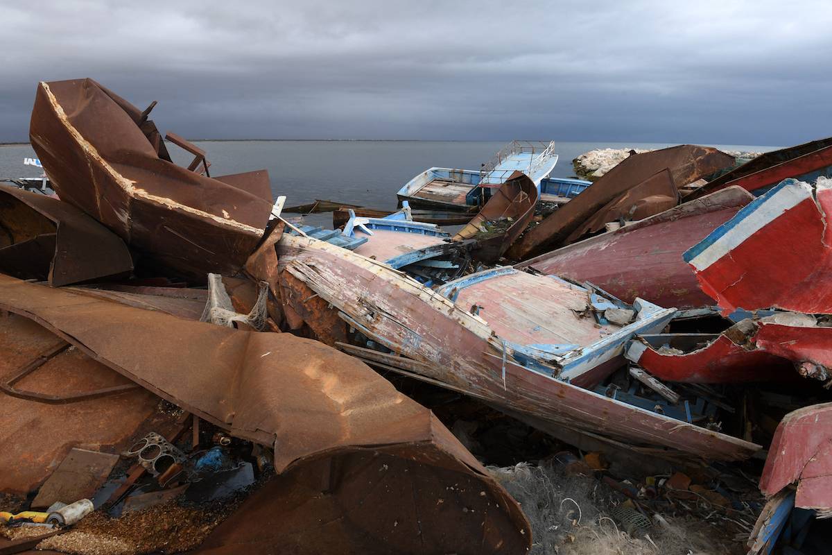 The remains of boats used by migrants to cross the Mediterranean to reach Europe are scattered along the port of El-Amra in Tunisia's Sfax governorate on April 24, 2024. [FETHI BELAID/AFP via Getty Images]