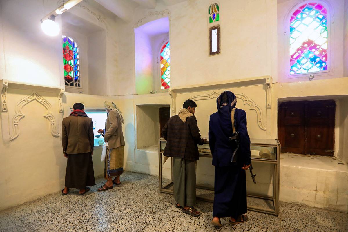 Visitors look at antiquities on display at the National Museum in the Huthi-held capital Sanaa on April 28, 2024. [Photo by MOHAMMED HUWAIS/AFP via Getty Images]