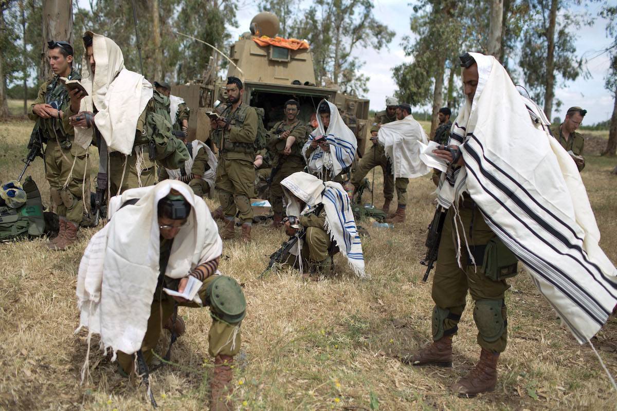 Israeli soldiers of the Jewish Ultra-Orthodox battalion "Netzah Yehuda" hold morning prayers as they take part in their annual unit training in the Israeli annexed Golan Heights, near the Syrian border on May 19, 2014. [MENAHEM KAHANA/AFP via Getty Images]