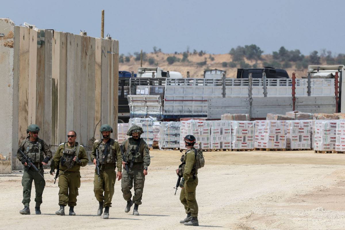 Israeli soldiers stand guard in Beit Hanun in the northern Gaza Strip during an operation of humanitarian aid delivered from Jordan to the Palestinian territory through the Israeli controlled Erez terminal, on May 1, 2024. [JACK GUEZ/AFP via Getty Images]