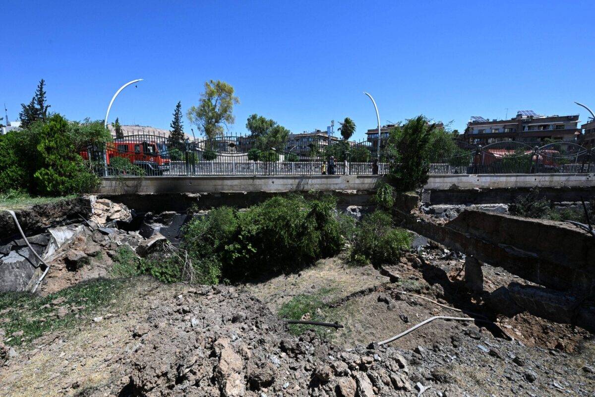 A fire truck is parked on a bridge near a crater caused by an Israeli strike in the neighbourhood of Kafr Sousse in Damascus, early on July 14, 2024 [LOUAI BESHARA/AFP via Getty Images]