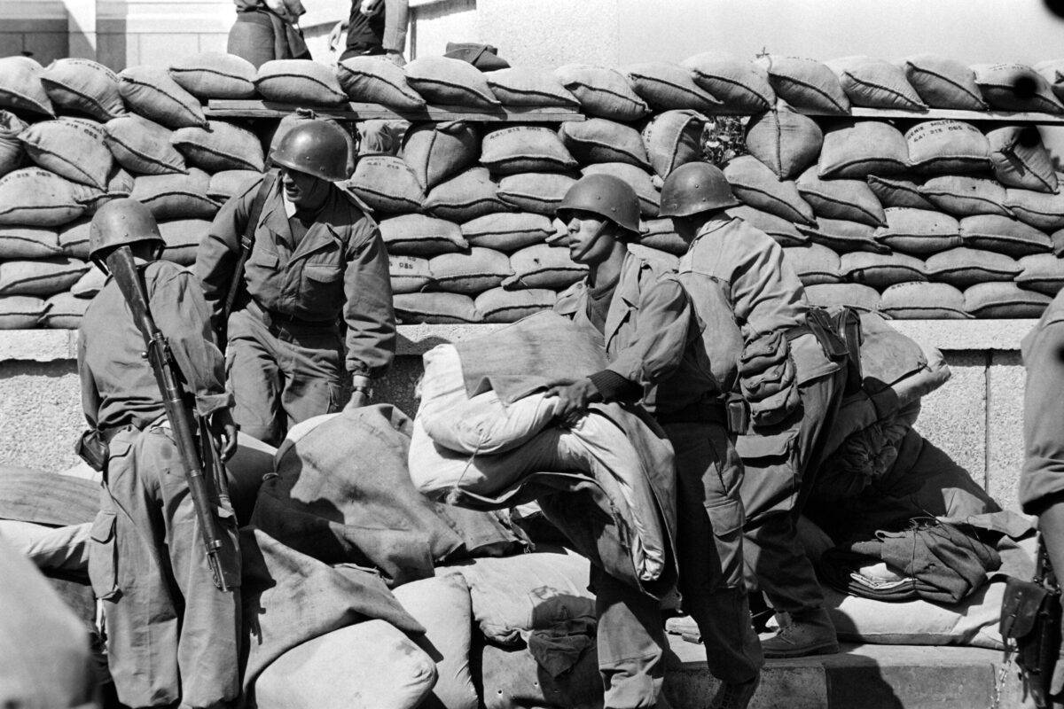 Algerian soldiers, who present themselves as part of the Local Force, guard the French Radio Television (RTF) building on May 3, 1962 in Algiers. [Photo by FERNAND PARIZOT/AFP via Getty Images]