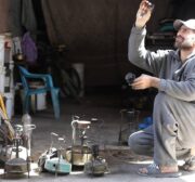Palestinians make a babur, a traditional kerosene stove, which is being manufactured in light of the cooking gas crisis in Gaza. [Mohammed Asad/MiddleEastMonitor]