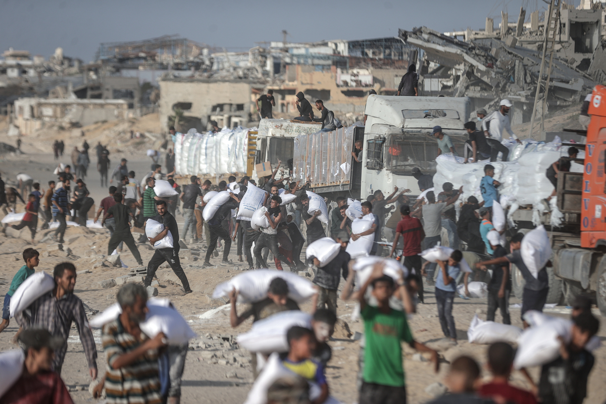 Palestinians receive aid supplies after aid trucks sent by the United Nations under Israeli attacks enter the Zakim border crossing under the protection of Palestinians and reached the warehouses in the north of in Gaza City, Gaza, on June 25, 2025. [Ali Jadallah - Anadolu Agency]