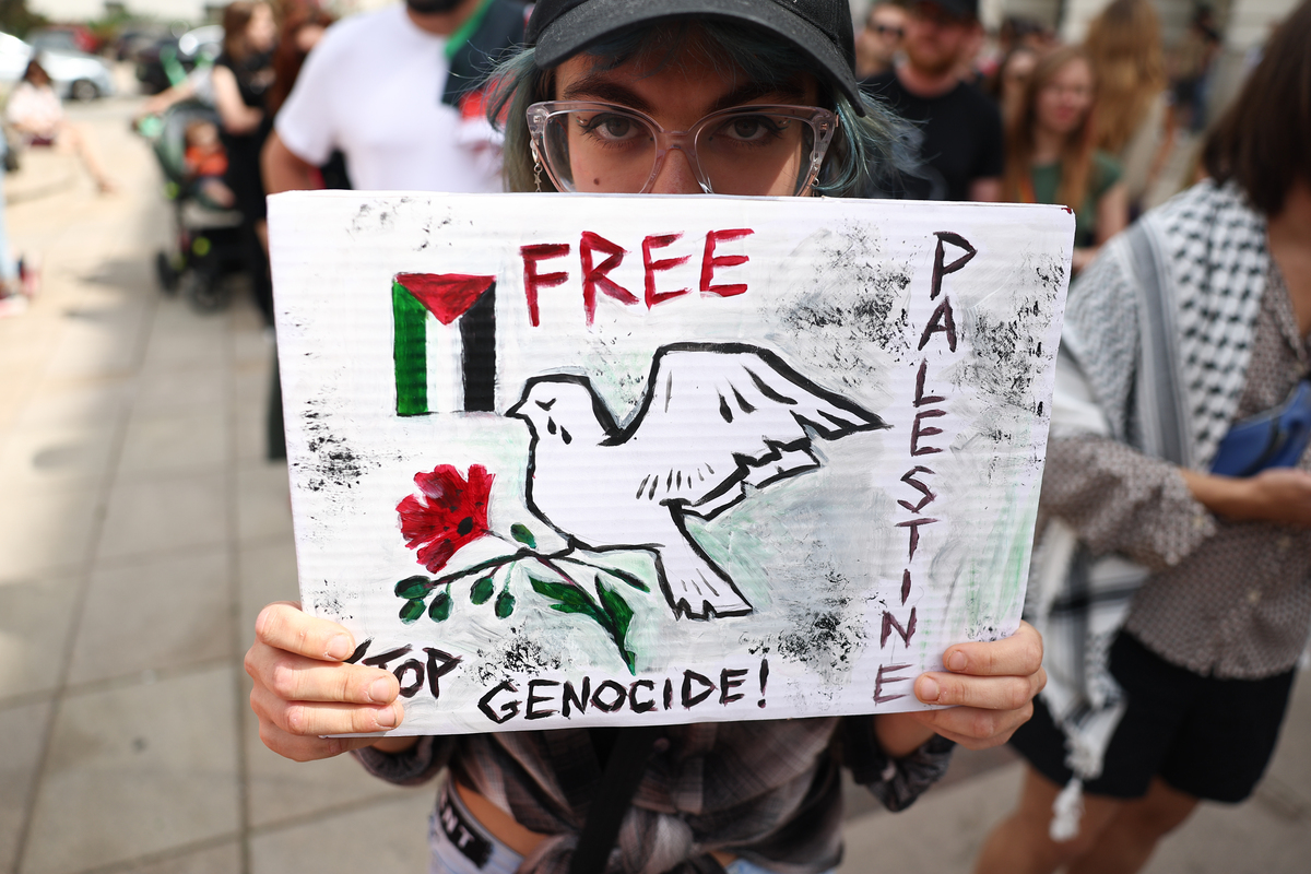 Protesters carry placards and Palestinian flags during the pro-Palestinian demonstration in Warsaw, Poland on August 17, 2025. [Jakub Porzycki - Anadolu Agency]