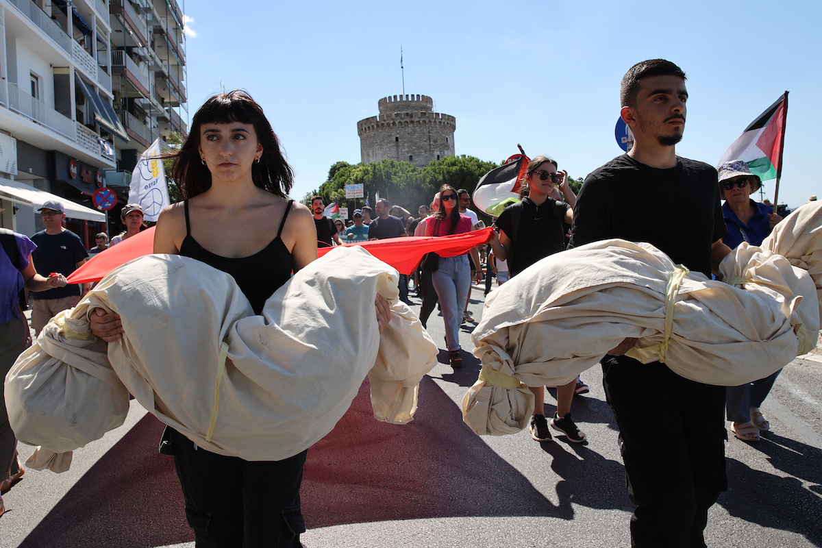 Some protesters carry shrouded mannequin models as hundreds of people gathered in White Tower Square, holding banners and Palestinian flags, march to protest Israel's attacks on Gaza and to show solidarity with the Palestinian people in Thessaloniki, Greece on August 24, 2025. The crowd, which included members of labor unions, youth organizations from left-wing parties, and many university students, attend the march held at noon. [Ayhan Mehmet - Anadolu Agency]