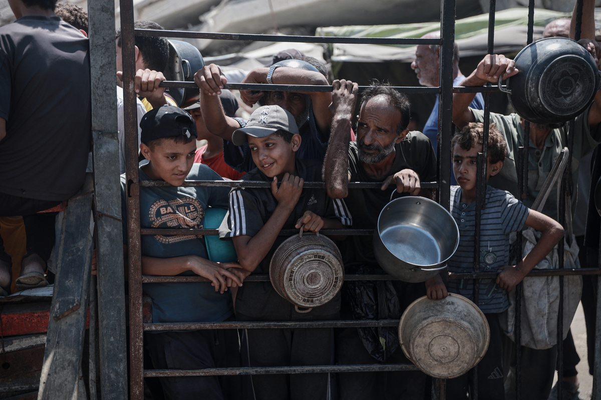 Palestinians, including children, who are struggling to access food due to Israel's blockade and ongoing attacks on the Gaza Strip, wait in line to receive hot meals distributed by the charity organization in Gaza City, Gaza on August 26, 2025. [Abdalhkem Abu Riash - Anadolu Agency]