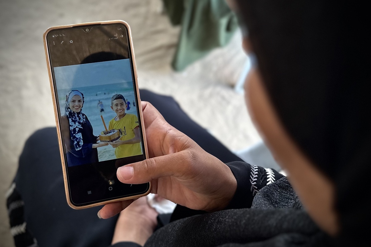 Neda Abu Dagga, sister of the Mariam Abu Dagga, one of the five journalists killed in the Israeli army's attack on Nasser Medical Complex in Khan Yunis on August 25, looks at an old photo on his phone screen during an exclusive interview in Khan Yunis, Gaza on August 27, 2025. [Doaa Albaz - Anadolu Agency]