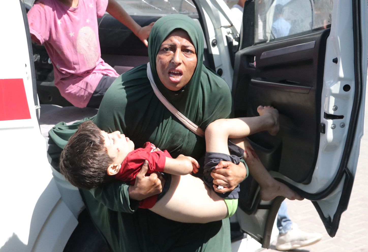 A woman carries an injured child in her arms as injured Palestinians, including children, are brought to al-Awda Hospital for medical treatment after the Israeli attacks on displaced Palestinian tents west of Nuseirat refugee camp in Gaza City, Gaza on September 26, 2025. [Fadel A. A. Almaghari - Anadolu Agency]