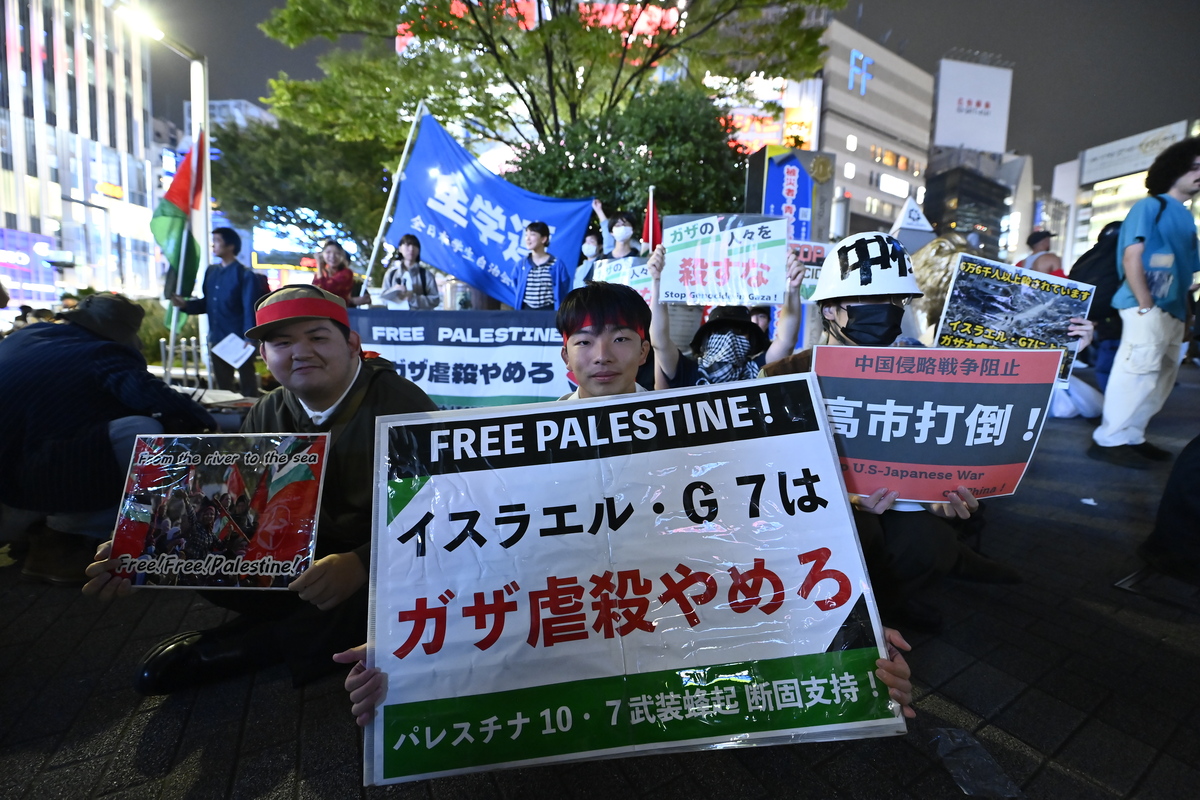 Demonstrators hold placards and chant anti-war slogans during a rally in Tokyo’s Shinjuku district, Japan, on October 7, 2025. [David Mareuil - Anadolu Agency]