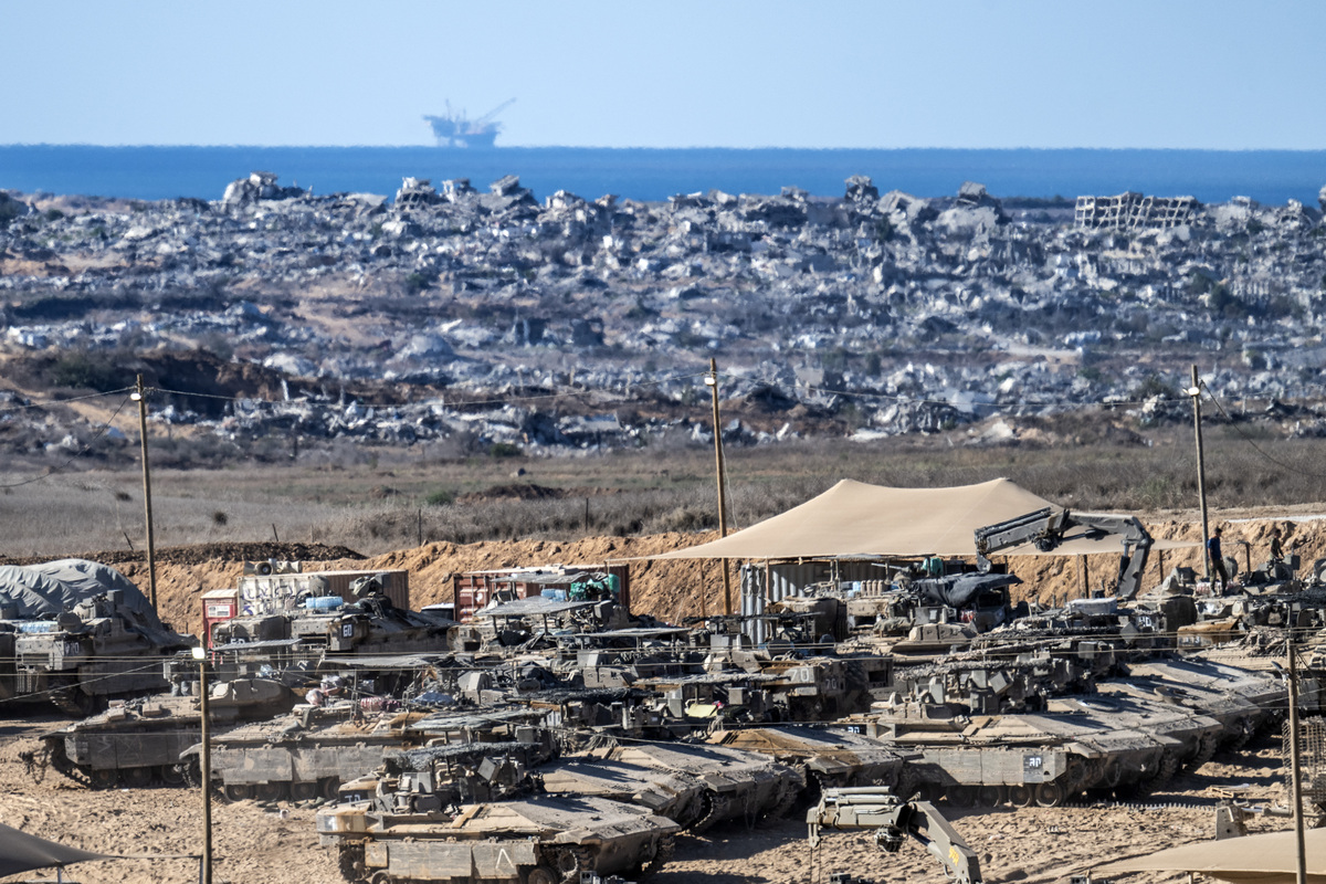 Israeli tanks and military vehicles are seen deployed with some military vehicles, helicopters, and drones patrolling along the border region following the implementation of the ceasefire between Israel and Hamas in Gaza and the withdrawal of Israeli forces inside the yellow line in Sderot, Israel on October 14, 2025. [Mostafa Alkharouf - Anadolu Agency]