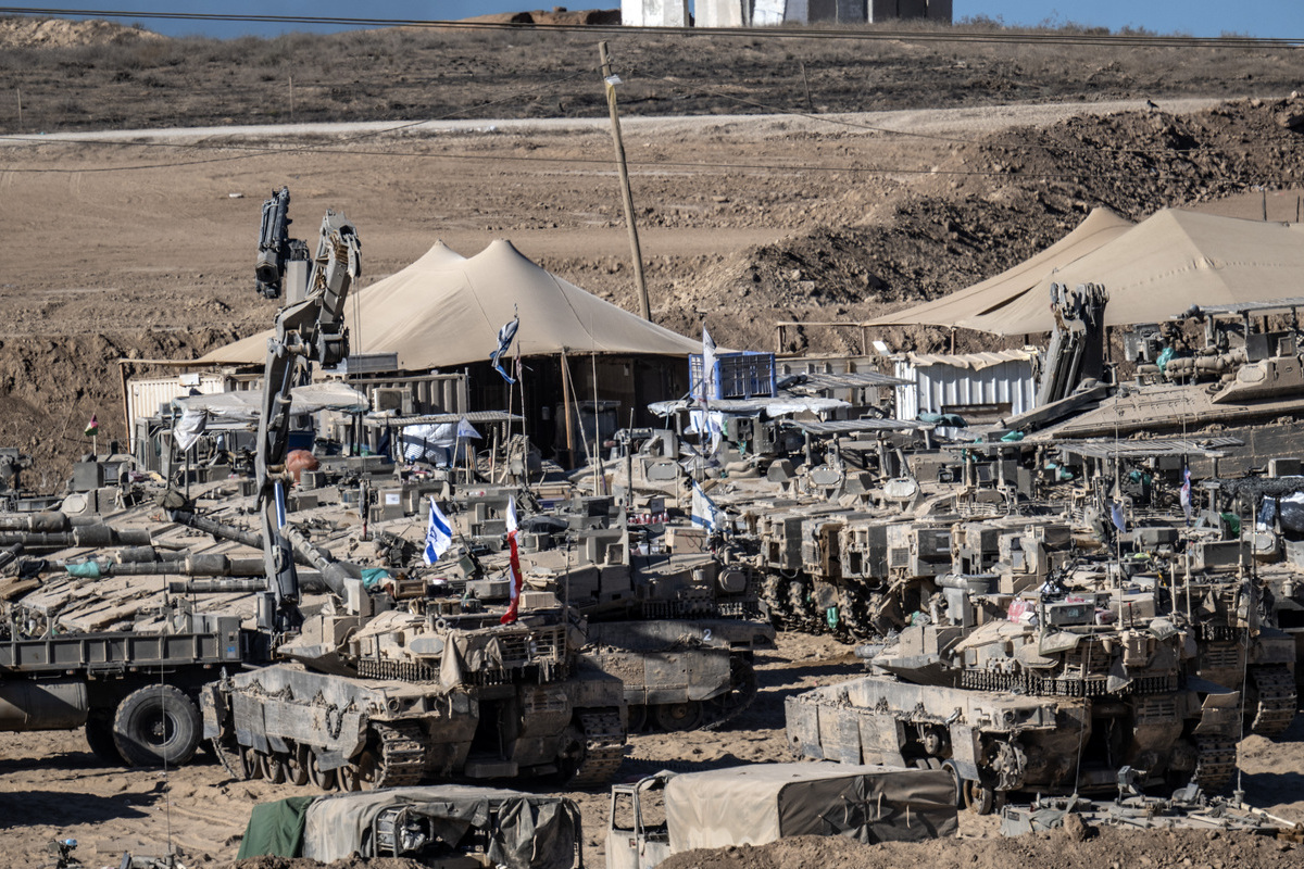 Israeli tanks and military vehicles are seen deployed with some military vehicles, helicopters, and drones patrolling along the border region following the implementation of the ceasefire between Israel and Hamas in Gaza and the withdrawal of Israeli forces inside the yellow line in Sderot, Israel on October 14, 2025. [Mostafa Alkharouf - Anadolu Agency]