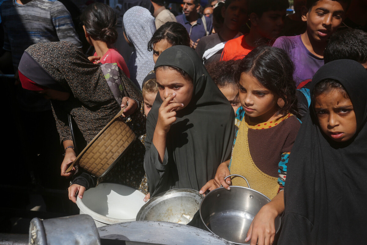 Palestinians, including women and children, form long queues in Deir al-Balah in the Gaza Strip to receive food distributed by charities, as thousands displaced by Israeli attacks depend on humanitarian aid to survive, on October 16, 2025. [Ashraf Amra - Anadolu Agency]
