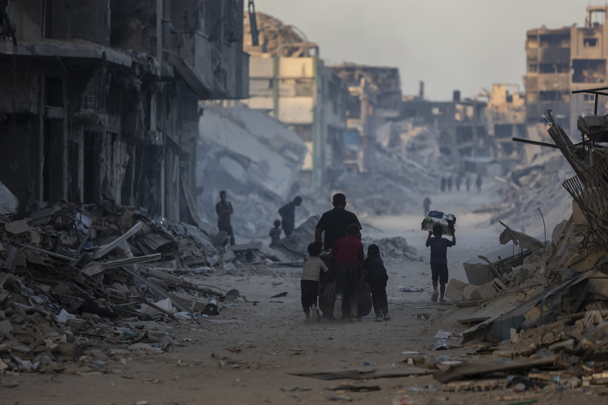Palestinians walk among the rubble of destroyed buildings on the streets of Sheikh Radwan district, devastated by Israeli bombings in Gaza City, Gaza on October 20, 2025. [Mahmoud Abu Hamda - Anadolu Agency]