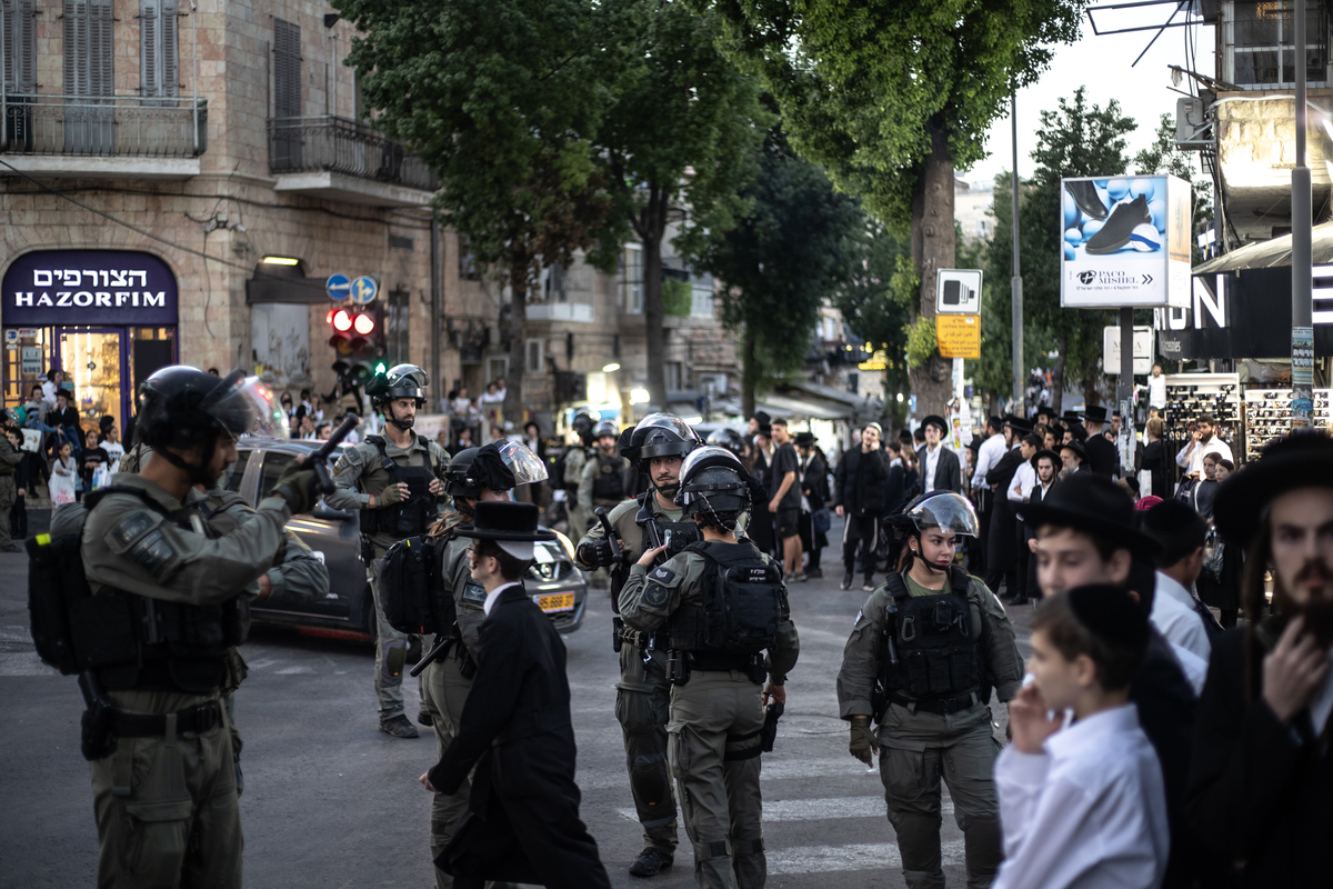 Police takes security measures as Ultra-Orthodox Jews (Haredim) gather to stage a protest against compulsory military service by blocking the main road and preventing the light rail from passing in Jerusalem on October 22, 2025. [Mostafa Alkharouf - Anadolu Agency]