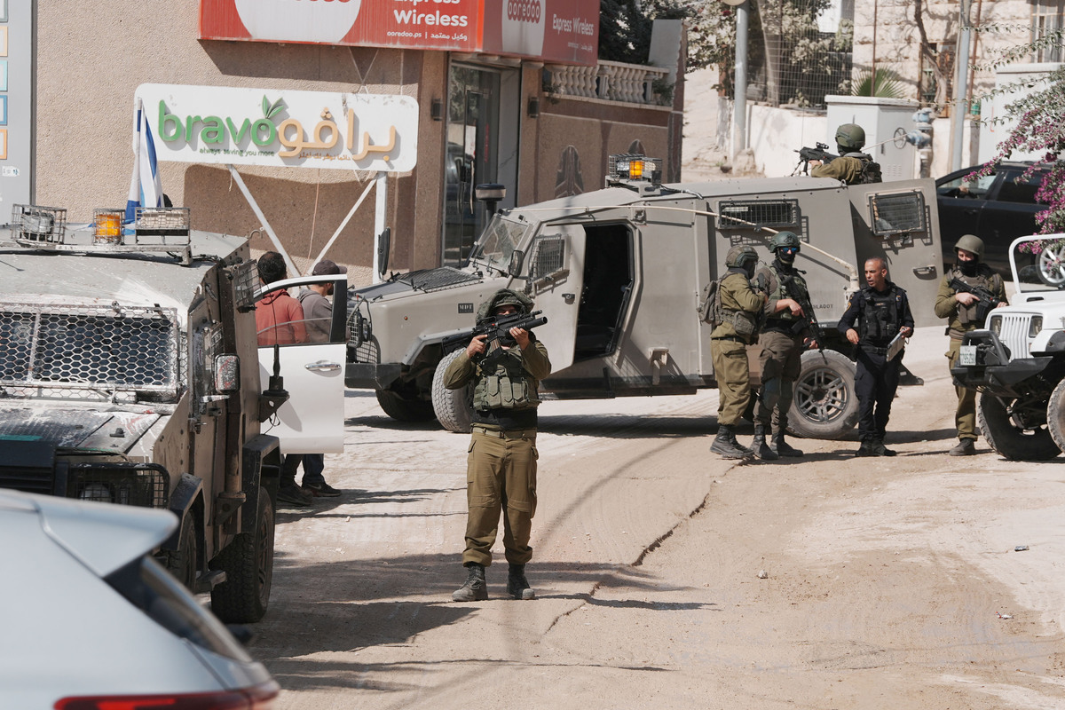 Israeli soldiers stand guard near armored vehicles during a raid following attacks by Israelis on Palestinians harvesting olives in the villages of Sinjil and Turmus Ayya near Ramallah, according to local sources in the West Bank, on October 28, 2025. [Issam Rimawi - Anadolu Agency]