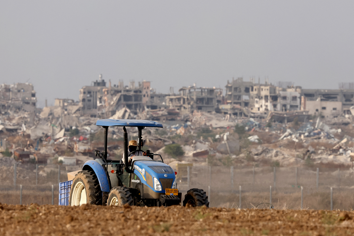 A farmer works the land near Israel's southern border with the Gaza Strip on December 11, 2024, amid the ongoing war between Israel and the militant group Hamas. [Photo by JACK GUEZ/AFP via Getty Image]