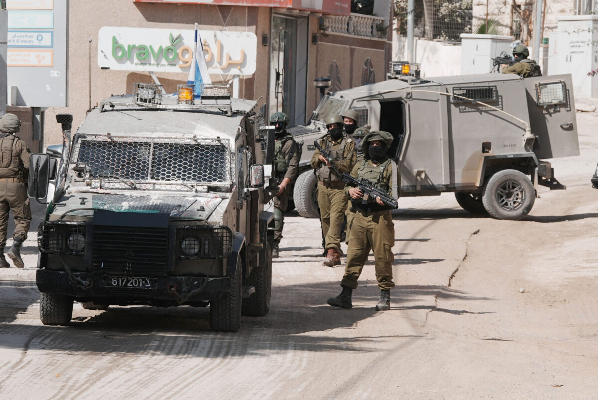 Israeli soldiers stand guard near armored vehicles during a raid following attacks by Israelis on Palestinians harvesting olives in the villages of Sinjil and Turmus Ayya near Ramallah, according to local sources in the West Bank, on October 28, 2025. [Issam Rimawi - Anadolu Agency]