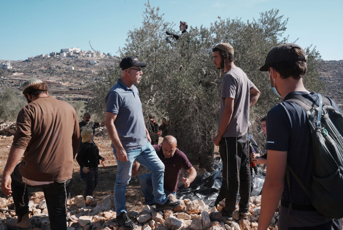 Jewish settlers argue with Palestinian farmers harvesting olives and activists supporting them and try to stop a group of people picking olives in Ramallah, West Bank on October 29, 2025. [Issam Rimawi - Anadolu Agency]