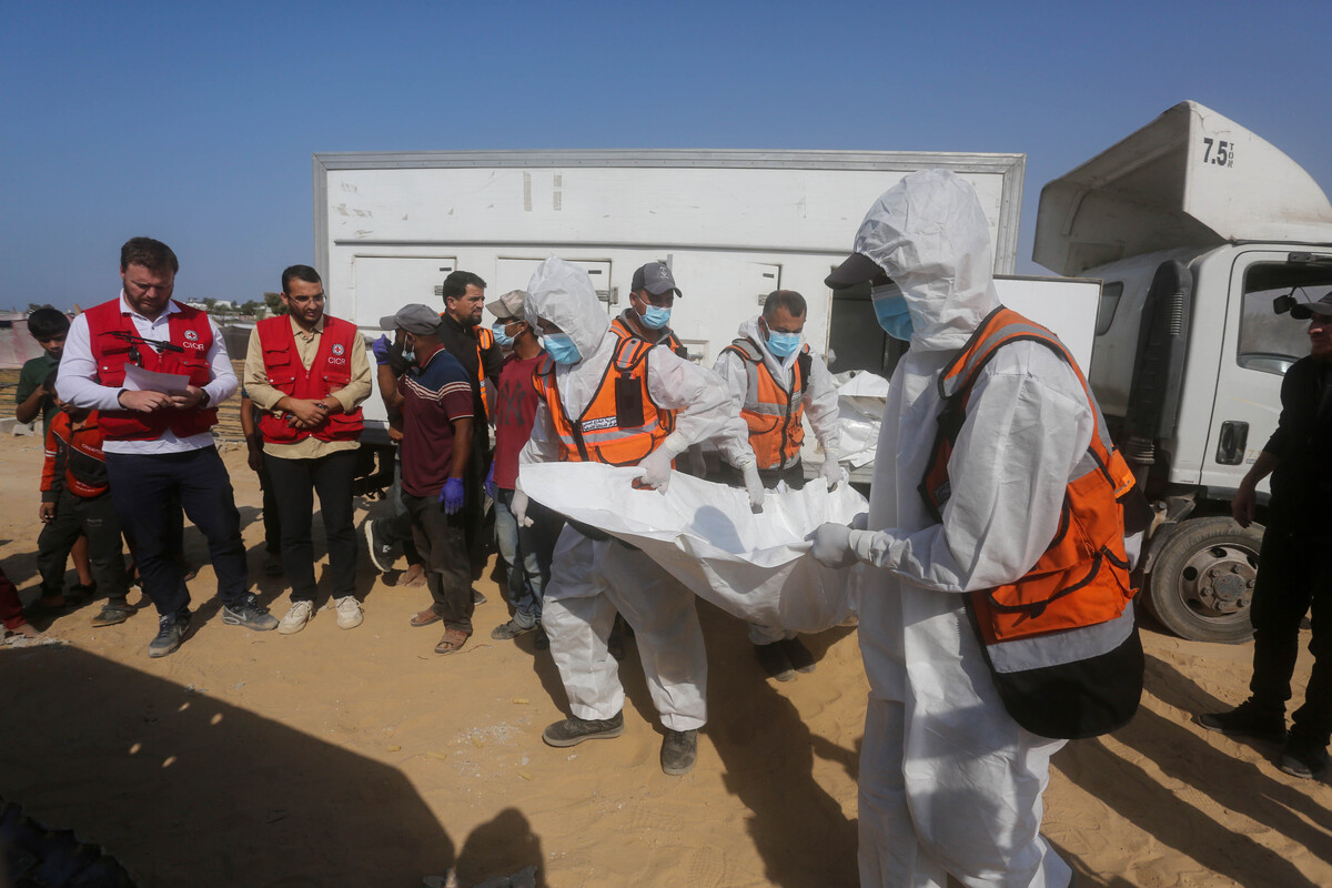 Civil defense and Red Cross teams are seen during the burial of 24 Palestinians whose bodies were handed over by Israel under the ceasefire agreement, in Deir al-Balah, Gaza, on November 5, 2025. [Stringer - Anadolu Agency]