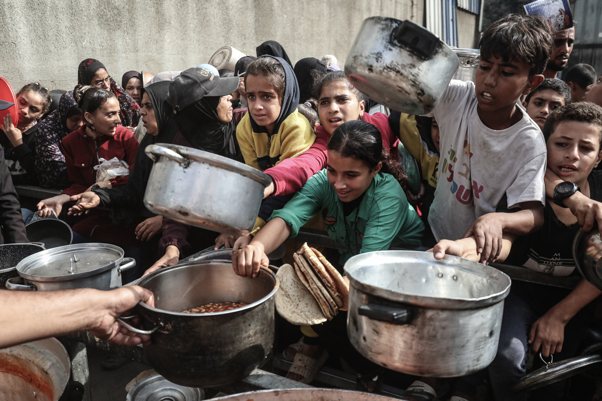 A charity organization distributes hot meals to displaced Palestinians in the Nuseirat Refugee Camp in central Gaza, where many have been forced to flee their homes due to Israeli attacks on November 12, 2025. [Moiz Salhi - Anadolu Agency]