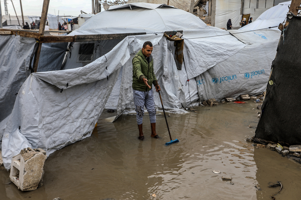 Displaced Palestinians try to drain water that has flooded their tents due to heavy rain and prevent damage to their belongings in Austrian Quarter of Khan Yunis, Gaza on November 16, 2025. [Abed Rahim Khatib - Anadolu Agency]