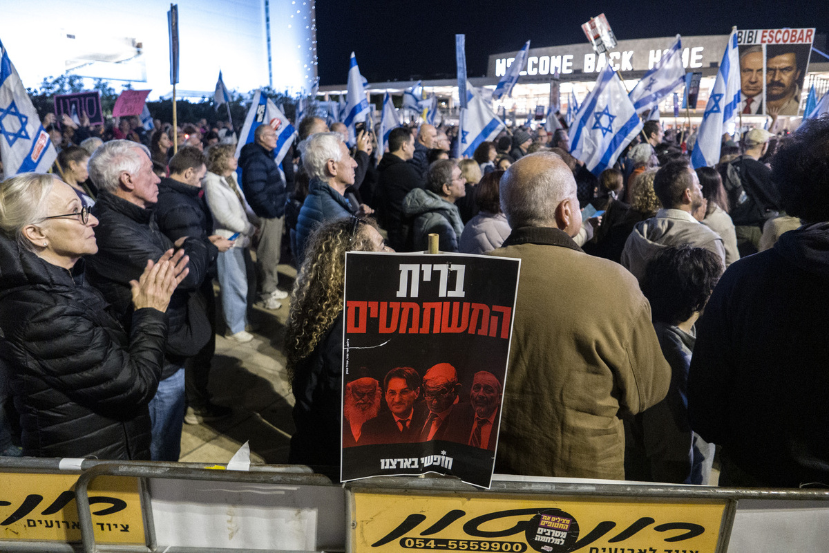 People carrying banners, gather at Habima Square to protest the Israeli government and call for the resignation of Benjamin Netanyahu in Tel Aviv, Israel on December 14, 2025. [Mostafa Alkharouf - Anadolu Agency]
