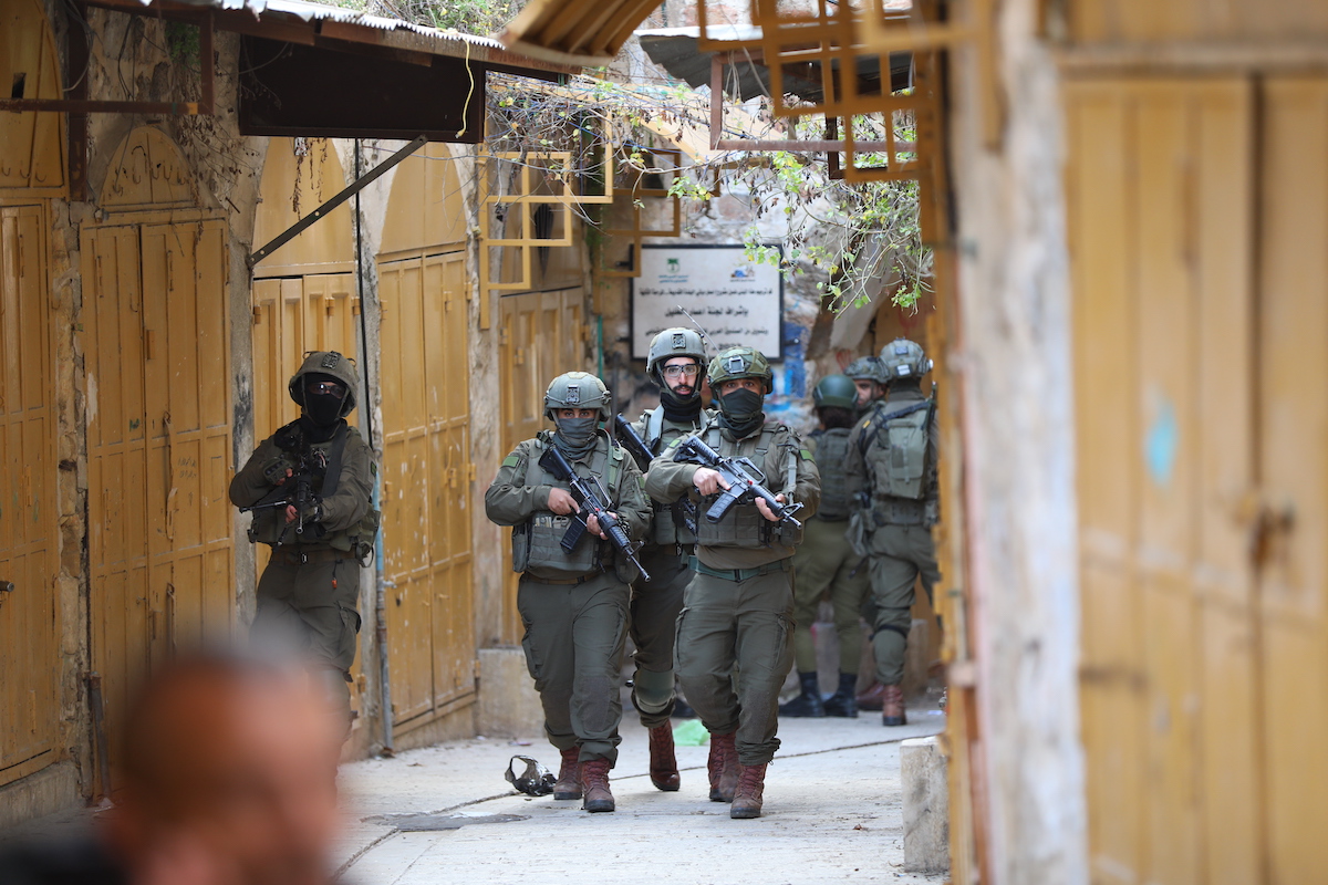 Israeli soldiers take security measures by closing off entry and exit points during raid by Jewish settlers, under the protection of Israeli forces, in Old City area of Hebron, West Bank on January 24, 2026. [Wisam Hashlamoun - Anadolu Agency]