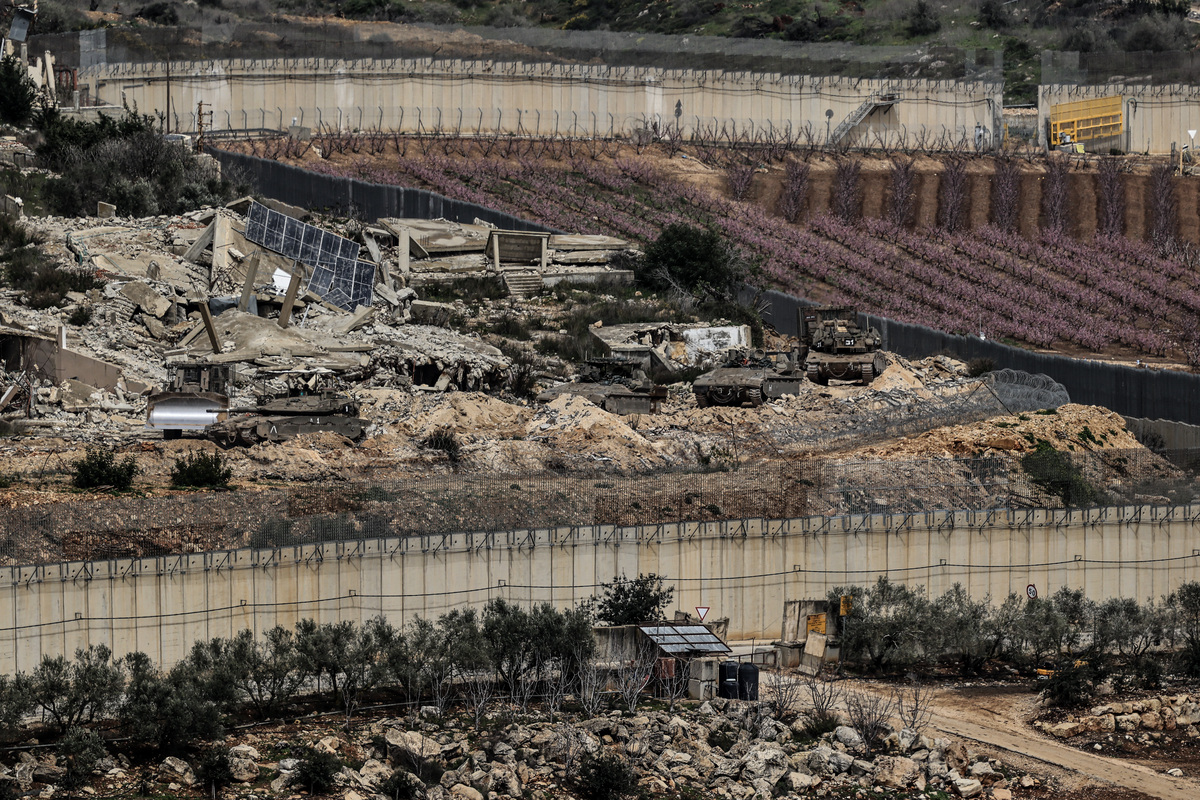 Israeli military vehicles and tanks are stationed in southern Lebanon, as seen from a vantage point in northern Israel on March 14, 2026. [Tsafrir Abayov - Anadolu Agency]