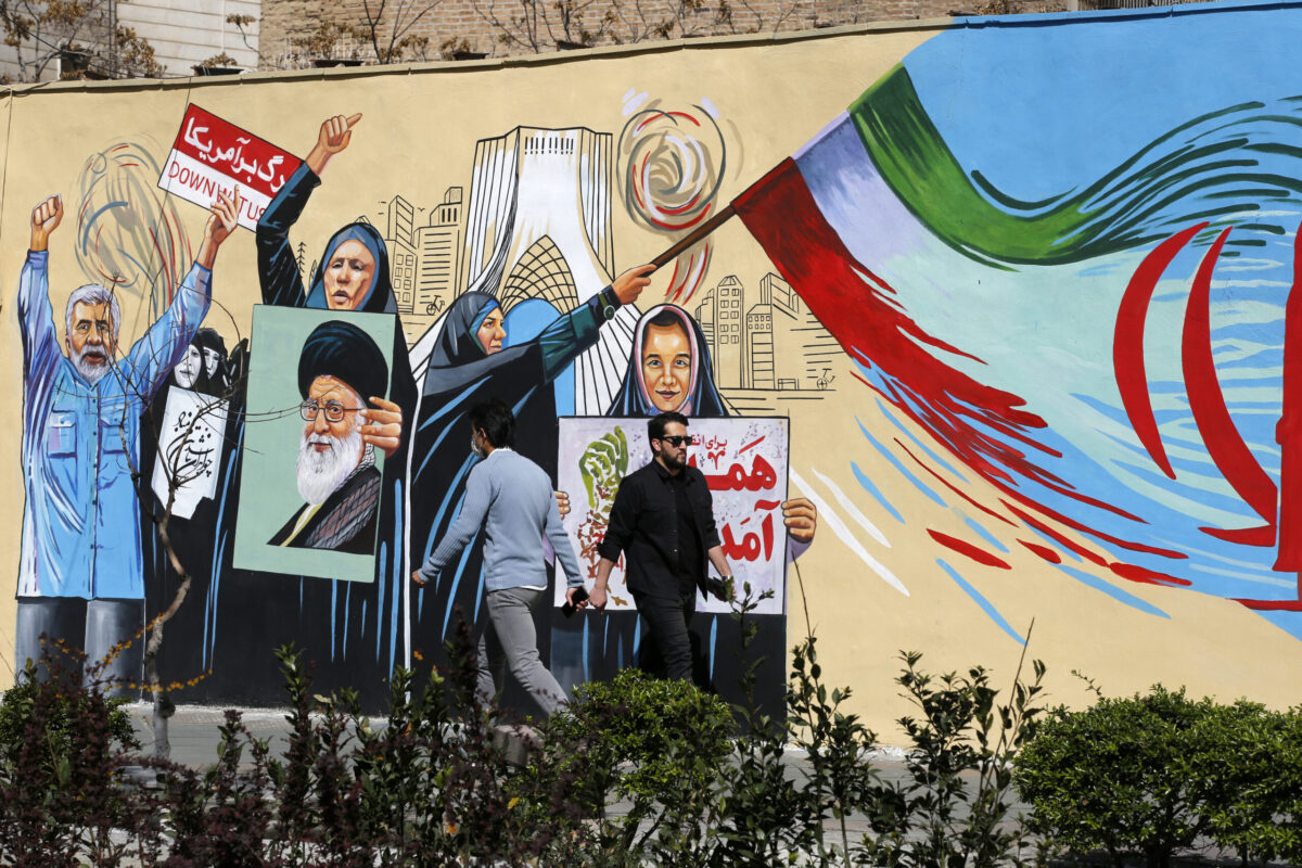 Residents walk past colorful wall paintings as daily life continues under the shadow of destruction following the U.S. and Israeli attacks on Tehran, Iran, on April 5, 2026. [Fatemeh Bahrami - Anadolu Agency]
