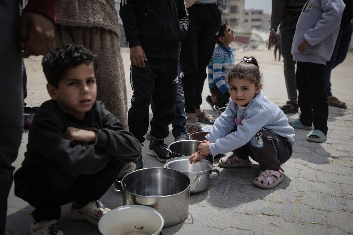 A charity distributes meals to displaced Palestinians in the Rimal Neighborhood as food shortages persist due to the Israeli policy on aid entering the Gaza City, Palestine, on April 15, 2026. [Ahmed Jihad Ibrahim Al-arini - Anadolu Agency]